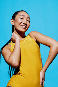 Portrait of young woman standing against clear blue sky