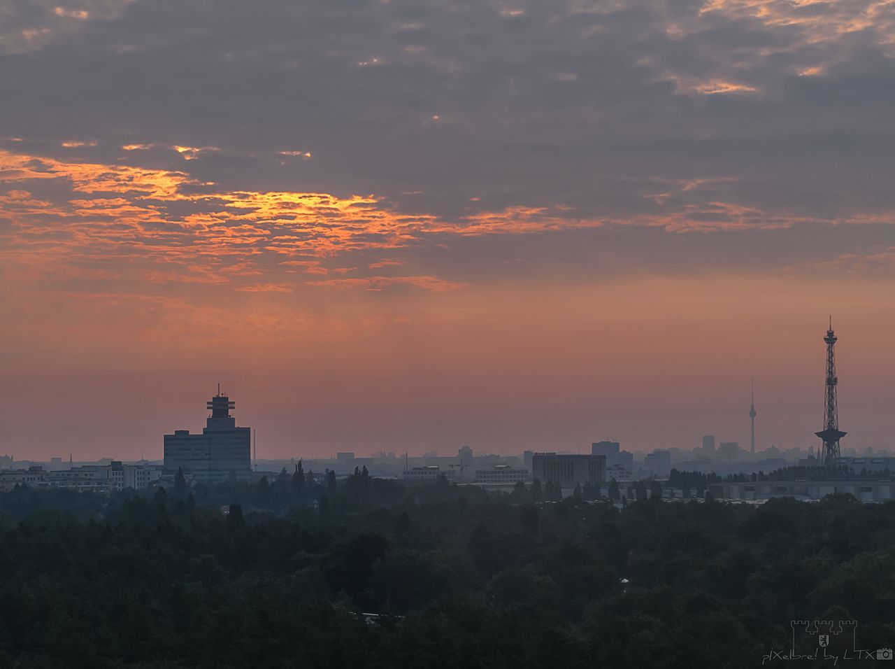 architecture, building exterior, built structure, sky, sunset, cloud - sky, orange color, building, nature, city, travel destinations, cityscape, no people, tower, outdoors, tall - high, tree, place of worship, religion, office building exterior, skyscraper