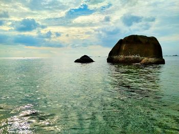 Scenic view of rocks in sea against sky