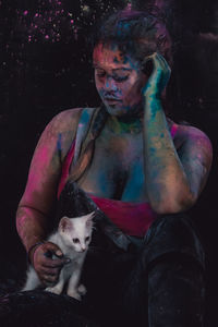 Woman with powder paint sitting with cat