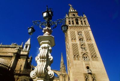 Low angle view of clock tower against clear blue sky