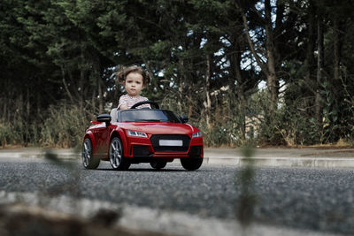 A girl riding a toy car