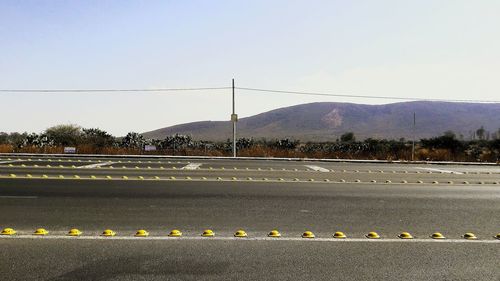 Road by land against clear sky
