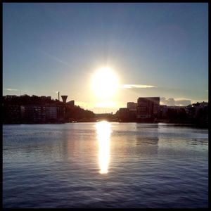 River with buildings in background at sunset