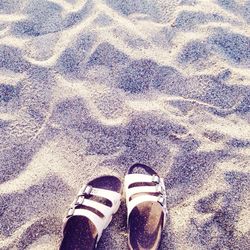 Low section of person standing on sand