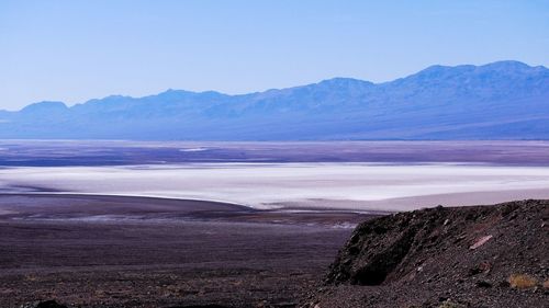 Scenic view of sea and mountains against sky