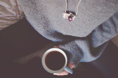 Midsection of woman holding coffee cup