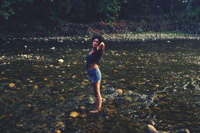 Full length of young woman standing on rock