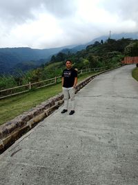 Full length of man standing on mountain against sky