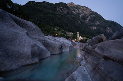 Scenic view of river amidst mountains looking towards the church
