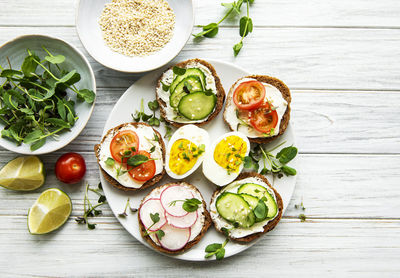 Sandwiches with healthy vegetables and micro greens on a wooden table