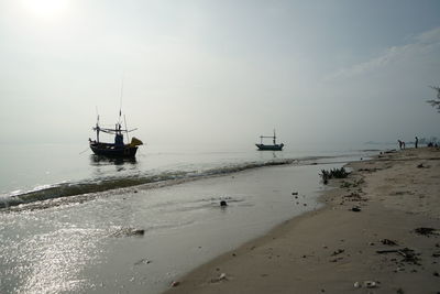 Sailboats in sea against sky