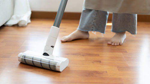 Low section of person standing on hardwood floor