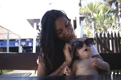 Portrait of young woman looking at camera with her baby