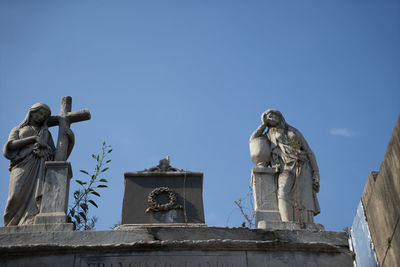 Low angle view of statue against blue sky