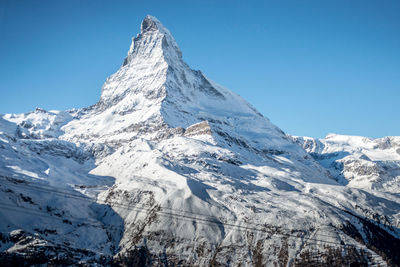 Scenic view of snowcapped mountains against blue sky