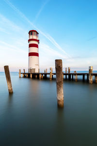 Lighthouse on sea against sky