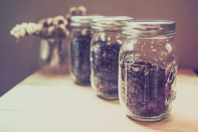 Close-up of coffee beans in glass jars on table