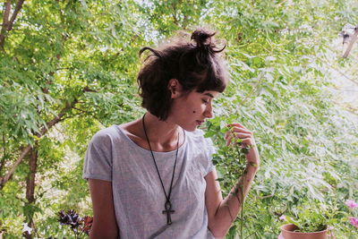 Young woman touching plants at park