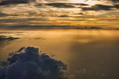 Scenic view of sea against dramatic sky during sunset