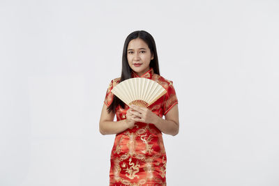 Portrait of a smiling young woman against white background
