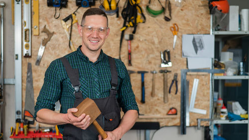 Portrait of smiling young man standing in workshop