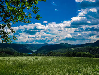 Scenic view of field against cloudy sky