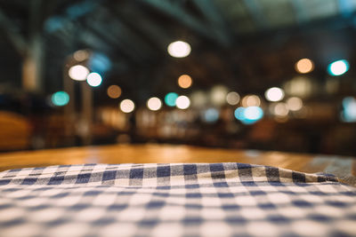 Close-up of napkin on table against illuminated lights