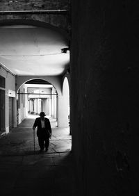Rear view of woman walking in corridor of building