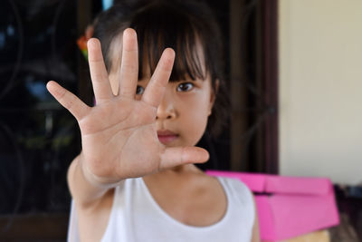 Close up of child girl showing stop hand signaling to stop against violence and pain. 