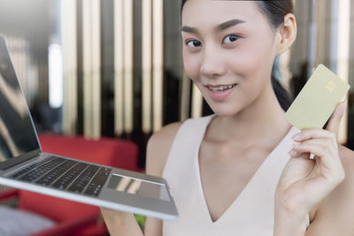 Portrait of smiling woman using mobile phone