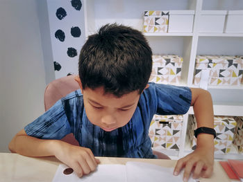 High angle view of boy studying at table