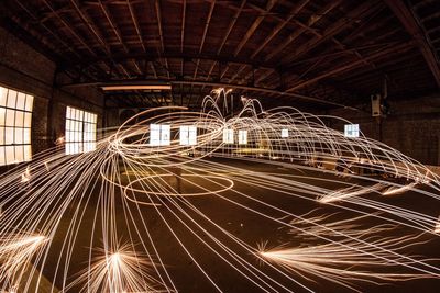 Person spinning firework in empty warehouse