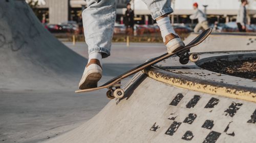 Low section of man skateboarding on street