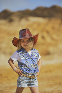Portrait of young woman wearing hat standing at beach
