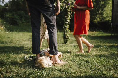 Girl lying on lawn between father's feet