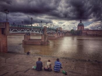 Bridge over river against cloudy sky