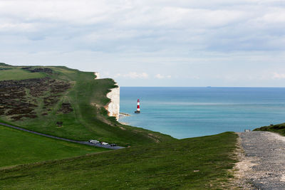 Cliff by sea against sky