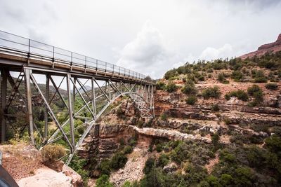 Arch bridge over landscape against sky