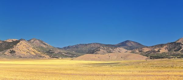 Scenic view of mountains against clear blue sky