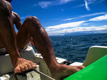 Man sailing in sea against sky