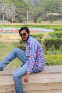 Portrait of young man sitting at park