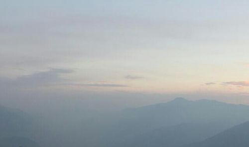 Scenic view of landscape against sky during foggy weather