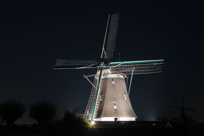 Low angle view of traditional windmill against sky at night