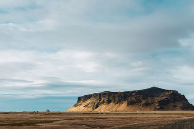 Scenic view of rocky mountains by sea against sky