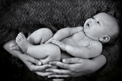 Baby boy lying in mothers arm