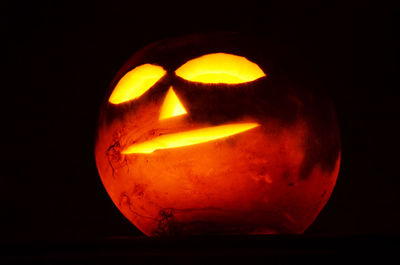 Close-up of illuminated lamp over black background