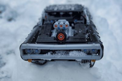 Close-up of snow covered car on field
