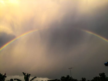 Low angle view of rainbow against sky at sunset