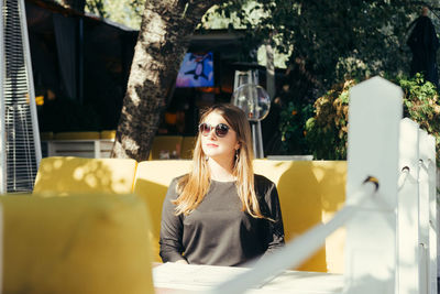 Young woman sitting with umbrella